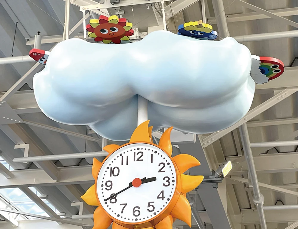 A mechanical clock featuring clouds and the sun as motifs.