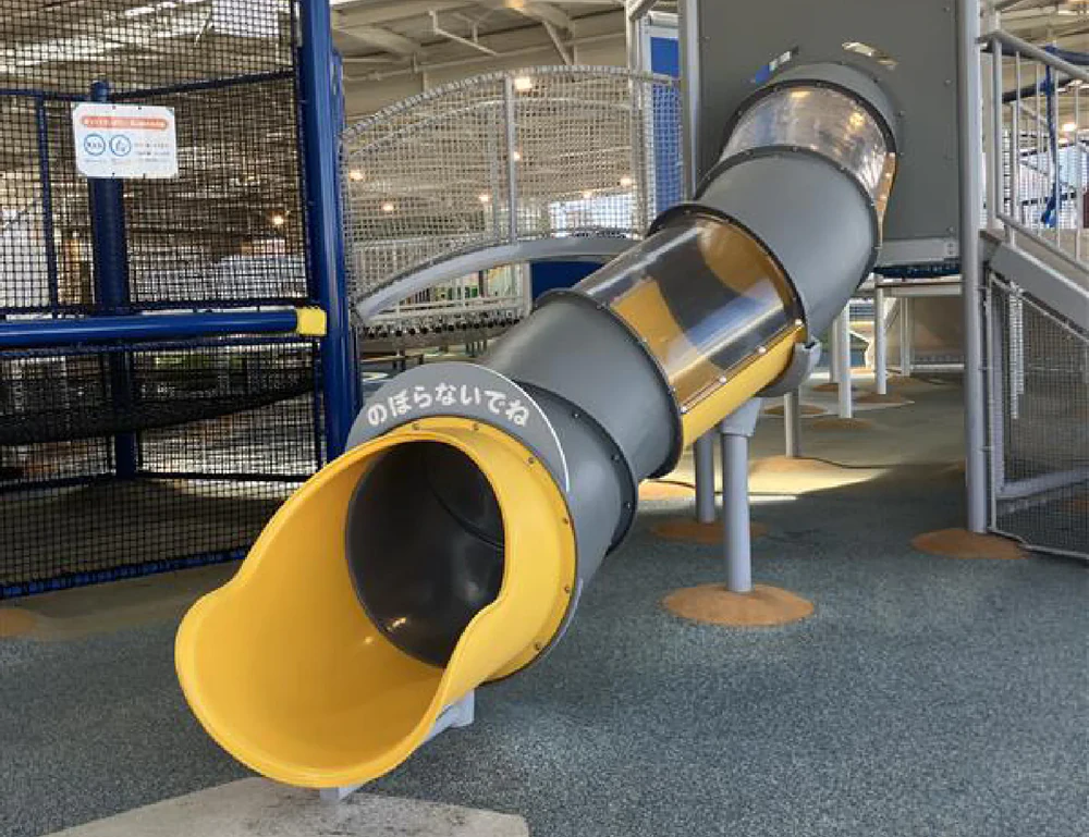 Cloud-themed athletic playground with a yellow tunnel-shaped slide